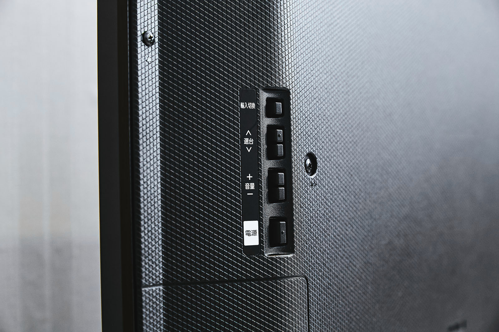 而機背除了豐富的傳輸介面群，帶來多樣化外接訊源的便利性外，也在另一側區域配置操控功能按鍵，主要作為切換訊源以及電視頻道選台和音量調控，與開/關機之用，雖然用到的頻率有限，但卻是相當實用的設計。