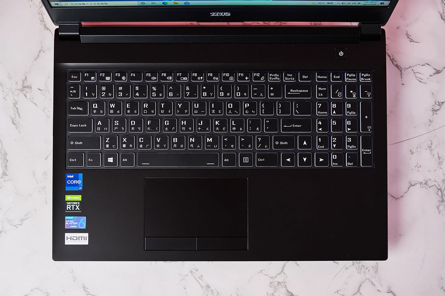 Genuine 捷元 ZEUS 15H 的機身 C 面空間較大，因此配置了帶九宮格數字鍵的孤島式鍵盤，下方也有大尺寸的觸控板。