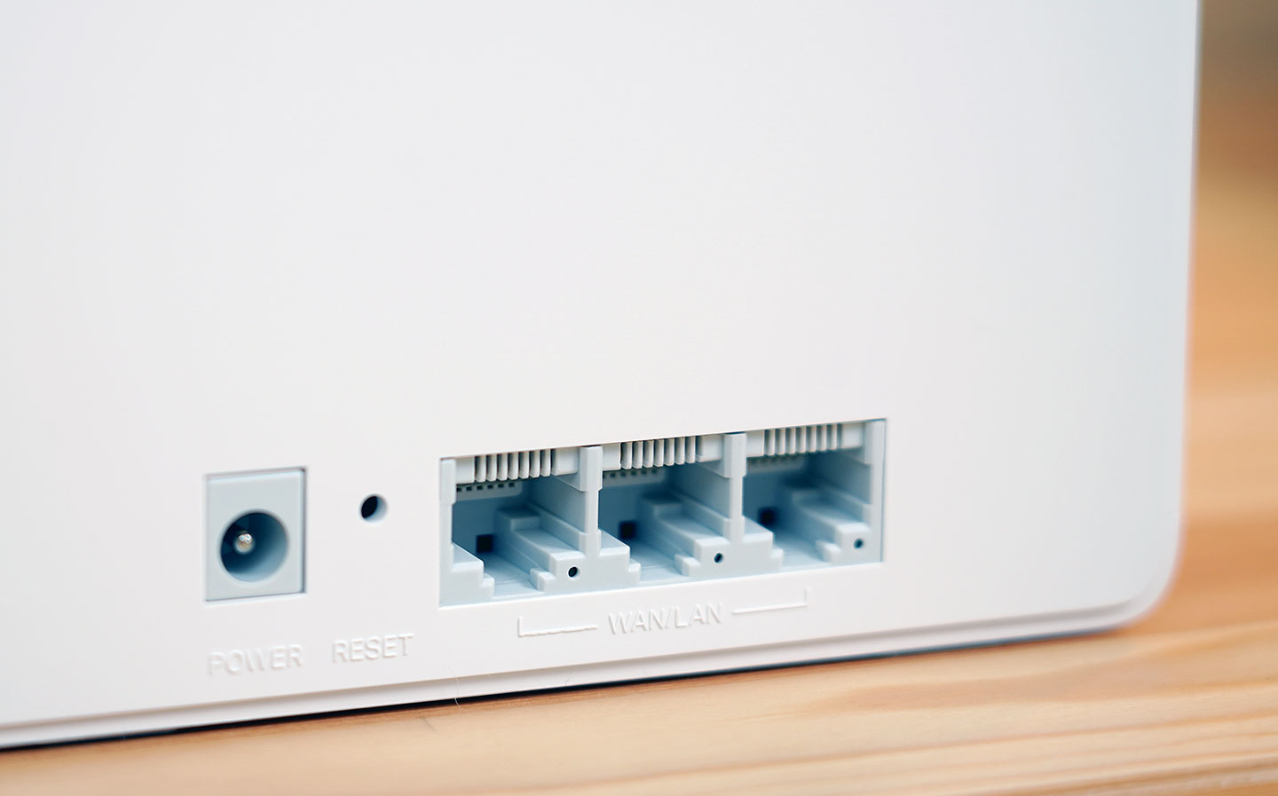 單一路由器內建有三組 Gigabit 規格的連結埠，且同時兼具 WAN 與 LAN 的功能，可由插入的纜線類型來自動切換，另外左方也有重置孔與電源接口。 ▲ 機身頂側設置有散熱孔，並採用三角型元素搭配的造型。 ▲ 機身底部也排佈了斜向線條的散熱孔與邊角的四個止滑墊。