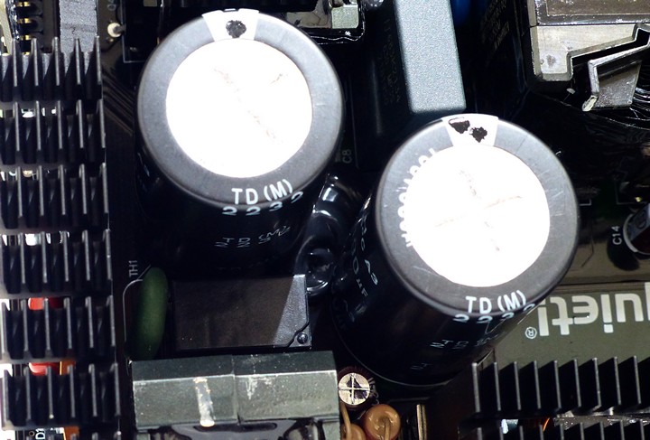 2 個 Teapo LH 系列 390μf/400V 大電容下方安排負溫度係數電阻（綠色圓餅零件），可降低湧浪電流，一旁則置繼電器（黑色長方形零件），於電源供應器常開機運作後，將負溫度係數電阻從電路上斷開，避免持續消耗能量並強化頻繁開關機的保能力。