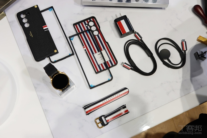 隨包裝配備二款皮革錶帶：黑色荔枝紋皮革，及紅、白、藍三色條紋皮革，這些經典配色同樣運用在 25W 旅充、圓形硬幣造型的手錶充電器，和 USB-C to USB-C 編織傳輸線。