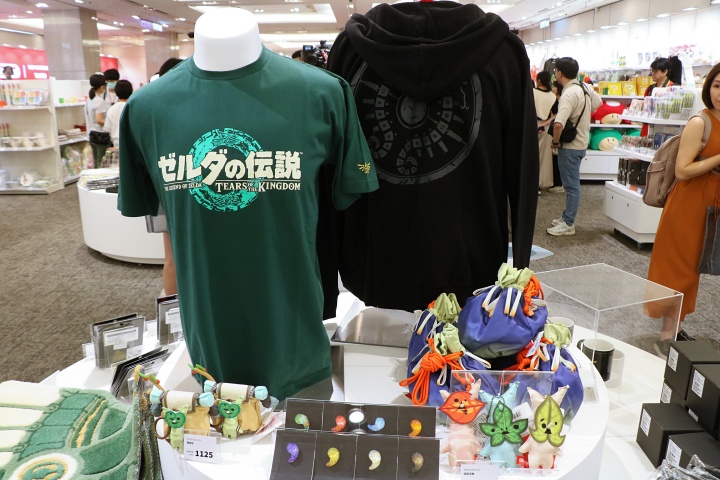 《薩爾達傳說：王國之淚》一系列周邊商品，包含 T-shirts、外套、情勒克洛格娃娃環保袋和掛件、炸彈花造型抽繩束口包和勾玉秘石實體化別針收藏品等。