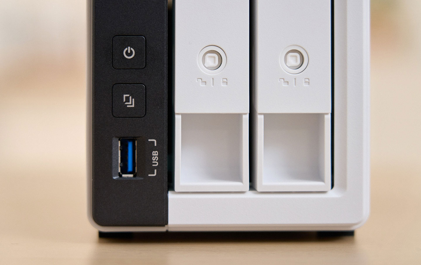 正面面板的實體按鈕包括電源、一鍵啟動備份（搭配下方的 USB Type-A 埠連結外部儲存設備），右方的硬碟槽也可以看到鎖孔，可搭配鑰匙鎖定硬碟槽，無法隨易拆卸下來。