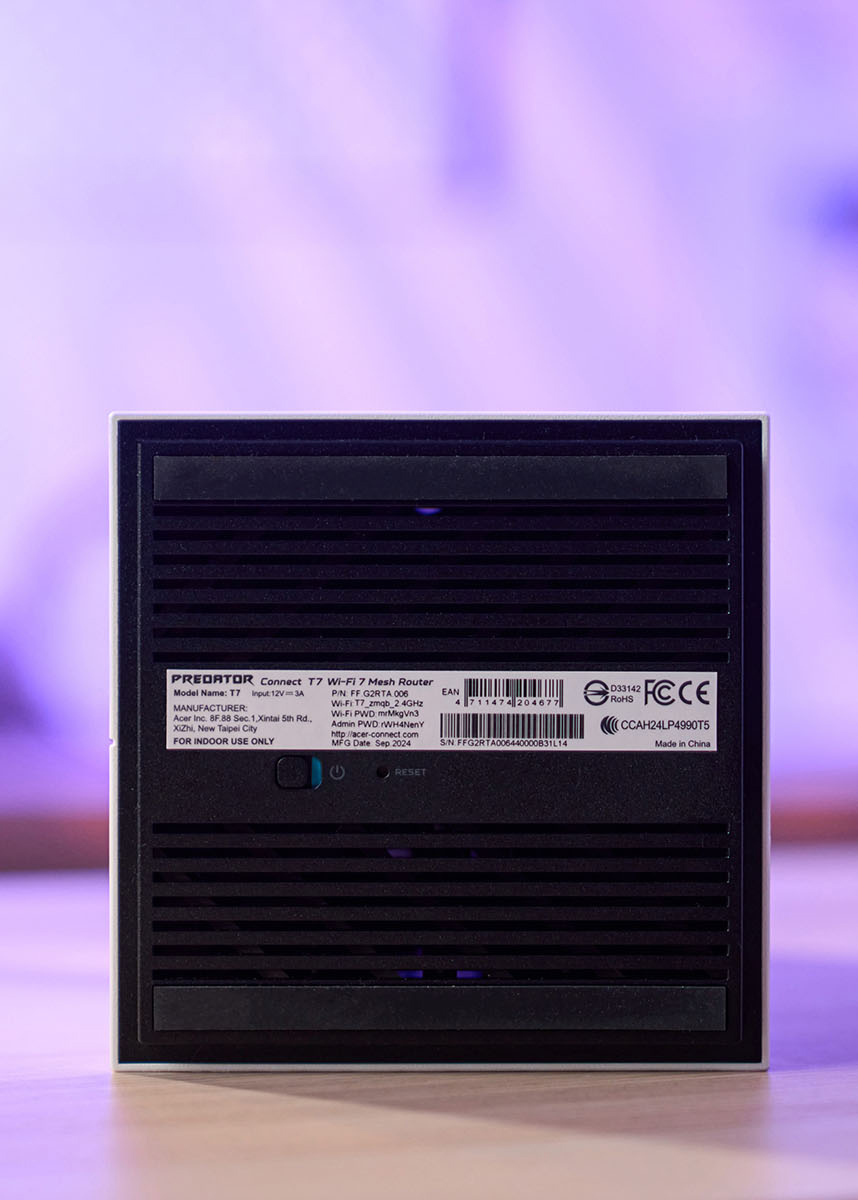 路由器底部規劃了散熱孔，標籤上有預設的 SSD 名稱、密碼與管理者密碼。
