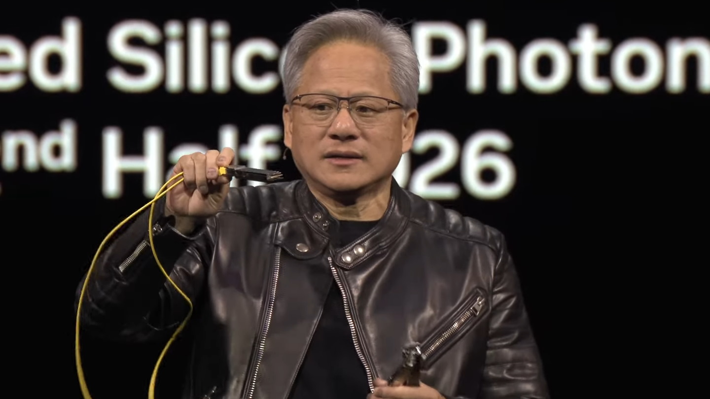 黃仁勳於演說中拿出光纖模組說明傳統光纖網路交換器較為耗電的原因。