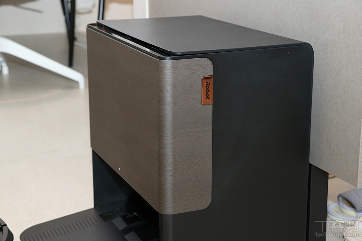 AutoWash 全能基座同樣採用異材質面板搭配深色霧面處理，外型線條俐落、整體風格偏向質感家電，擺放在客廳或開放式空間也十分美觀。